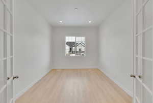 Empty room with light wood-type flooring, baseboards, and recessed lighting