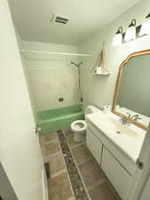 Full bathroom with vanity, tile patterned flooring, tiled shower / bath combo, and toilet