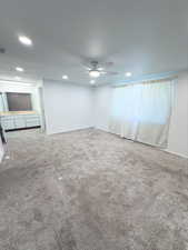 Carpeted empty room featuring ceiling fan