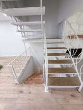 Staircase featuring hardwood / wood-style flooring