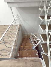 Staircase featuring hardwood / wood-style flooring