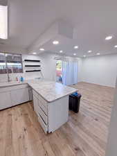 Kitchen featuring sink, light hardwood / wood-style flooring, and white cabinets