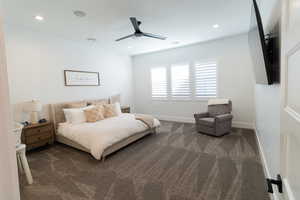 Primary Bedroom with ceiling fan and dark colored carpet