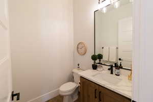 Bathroom with vanity, wood-type flooring, and toilet