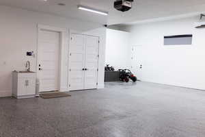 Garage featuring a garage door opener and sink