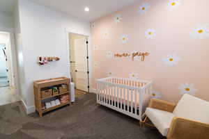 Carpeted bedroom with a nursery area