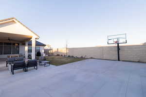 Patio terrace at dusk featuring an outdoor hangout area and ceiling fan