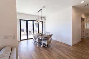 Dining area featuring french doors, dark hardwood / wood-style floors, and a notable chandelier