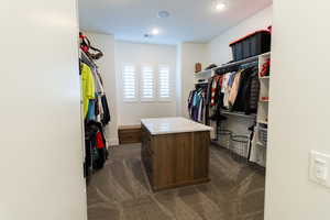 Walk in closet with dark carpet