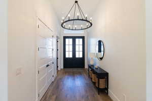 Entrance foyer with a high ceiling, dark hardwood / wood-style floors, and french doors