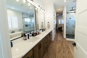 Primary Bathroom featuring vanity, a wealth of natural light, independent shower and bath, and wood-type flooring