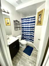 Bathroom with vanity, toilet, hardwood / wood-style floors, and walk in shower