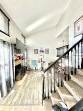 Stairs with a tiled fireplace and hardwood / wood-style floors