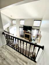 Stairs with hardwood / wood-style flooring and a fireplace