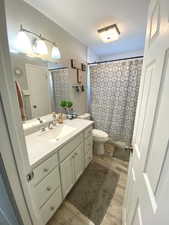 Bathroom featuring vanity, hardwood / wood-style floors, and toilet