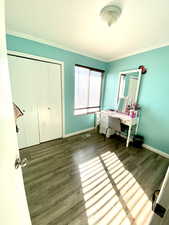 Bedroom featuring crown molding, hardwood / wood-style floors, and a closet