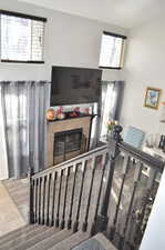 Stairs with hardwood / wood-style floors and a fireplace