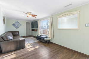 Living room featuring crown molding, ceiling fan, and hardwood / wood-style flooring