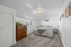 Bedroom featuring lofted ceiling and carpet flooring