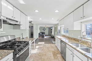 Kitchen with white cabinetry, appliances with stainless steel finishes, and sink