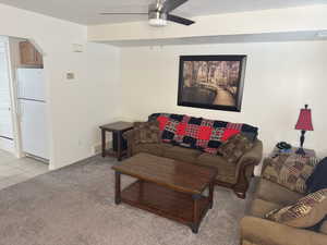 Living room featuring light carpet and ceiling fan