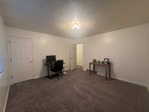 Carpeted office with a textured ceiling