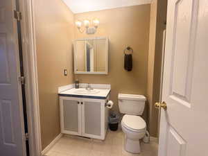 Bathroom featuring vanity, tile patterned floors, and toilet