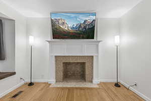 Interior details featuring hardwood / wood-style floors and a tile fireplace