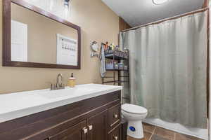 Bathroom featuring vanity, tile patterned floors, and toilet