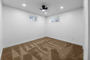 Carpeted empty room featuring ceiling fan