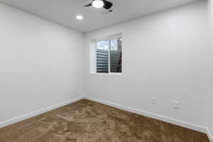 Carpeted spare room featuring ceiling fan