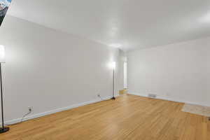 Empty room with light hardwood / wood-style floors