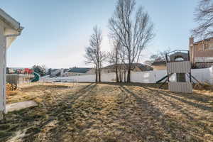 View of yard featuring a playground and a trampoline.