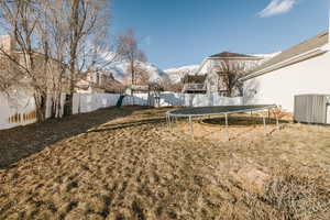 View of fully fenced yard featuring a playground and a mountain view