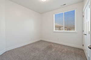 Bedroom #2. Spare room featuring carpet floors and large window.