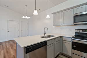 Kitchen featuring pendant lighting, sink, kitchen peninsula, and appliances with stainless steel finishes.