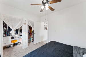 Carpeted bedroom with ceiling fan