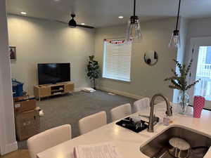 Carpeted living room featuring sink and ceiling fan