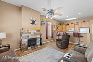 Living room featuring ceiling fan, light hardwood / wood-style floors, and a tile fireplace