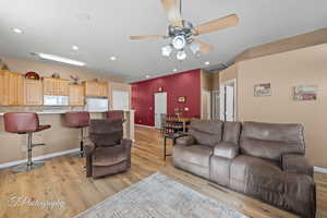 Living room with light hardwood / wood-style floors and ceiling fan