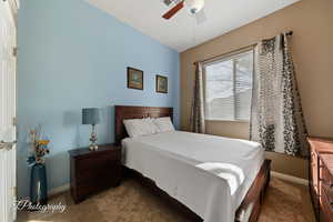 Carpeted bedroom featuring ceiling fan