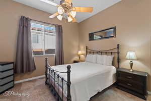 Bedroom featuring ceiling fan and carpet