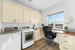 Laundry room with cabinets, independent washer and dryer, light hardwood / wood-style floors, and sink