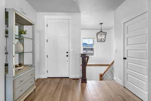 Entryway with a chandelier and light hardwood / wood-style floors