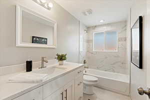 Full bathroom featuring vanity, toilet, and tiled shower / bath