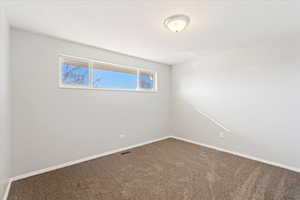 Spare room with a textured ceiling and carpet