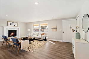 Living room featuring dark wood-type flooring, a fireplace, and a textured ceiling