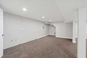 Basement featuring dark colored carpet