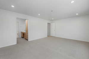 Unfurnished bedroom with light colored carpet and ensuite bath