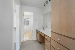 Bathroom featuring vanity, a tub to relax in, tile patterned flooring, and toilet